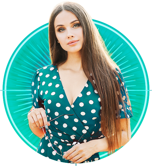 Mulher bonita de vestido verde segurando os óculos nas mãos.